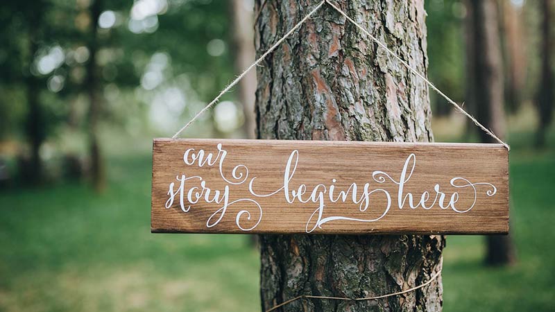 A Sign on a Tree That Says Our Story Begins Here